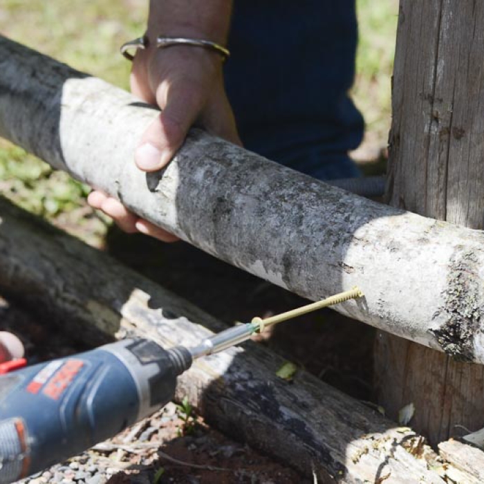 Screwing the railing into a fence for sapling fence